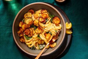 Plate of spaghetti topped with crispy zucchini slices.