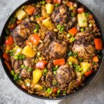 One-skillet meal featuring jerk-seasoned chicken, rice, and assorted vegetables.