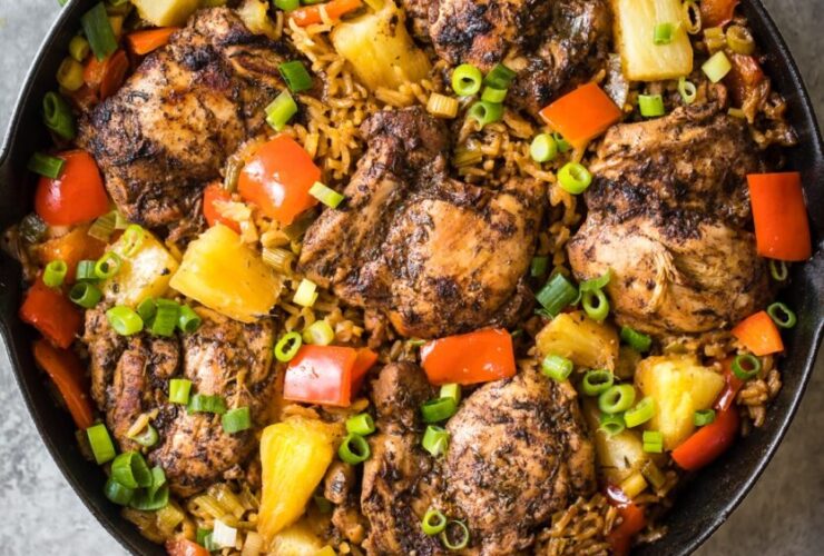 One-skillet meal featuring jerk-seasoned chicken, rice, and assorted vegetables.