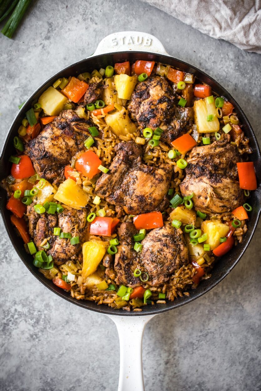 One-skillet meal featuring jerk-seasoned chicken, rice, and assorted vegetables.