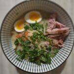 a bowl of soup with meat and noodles