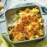 overhead shot of golden bubbly roasted broccoli and cauliflower pasta bake in ceramic baking dish with melted cheese on top