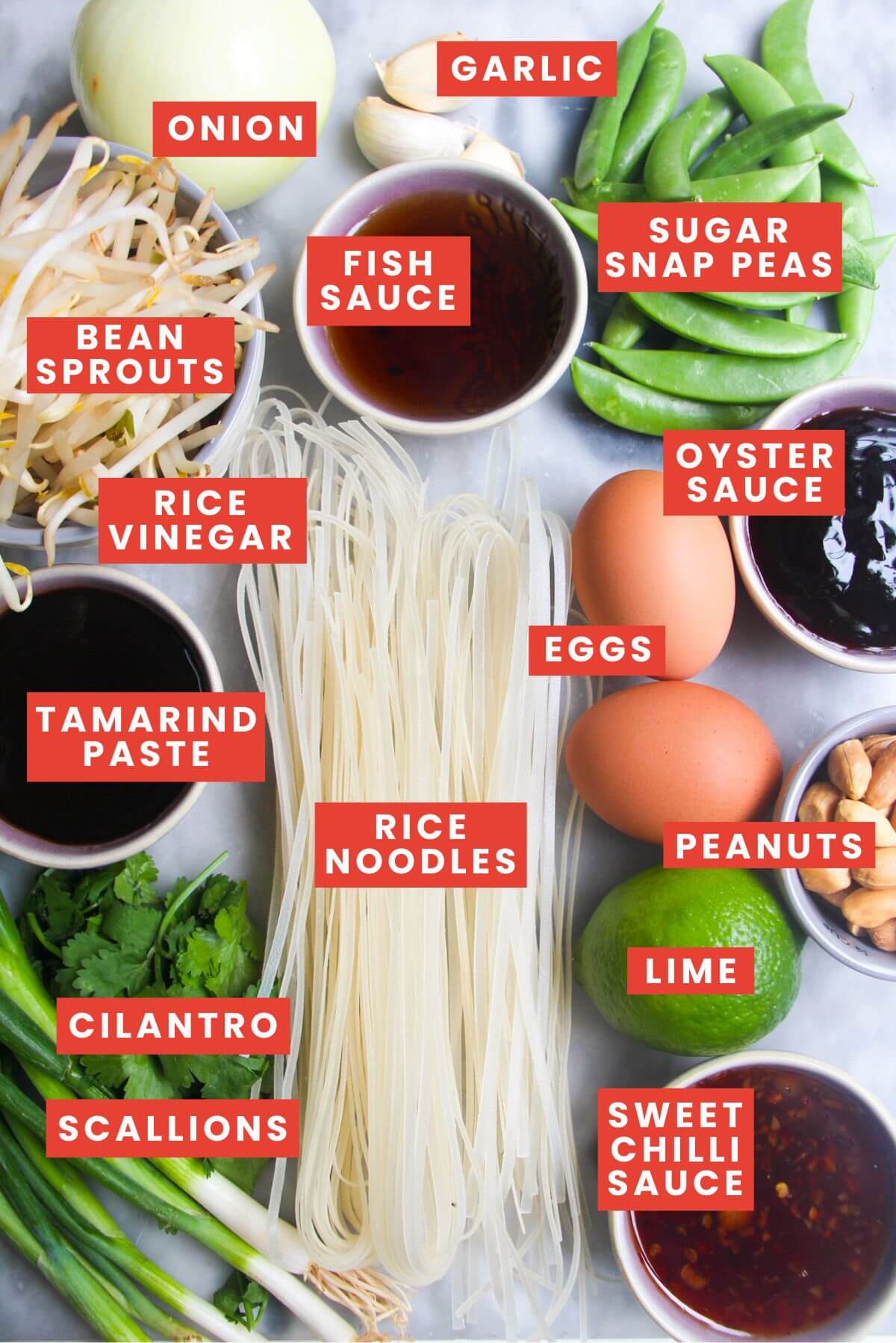 Pad thai ingredients laid out including rice noodles tamarind paste fish sauce bean sprouts and lime