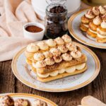Classic tiramisu in individual glass portions with perfectly dusted cocoa powder on top, garnished with coffee beans