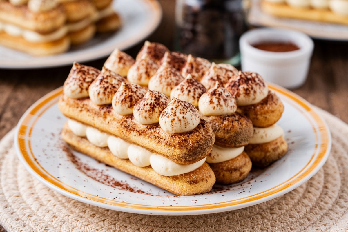 Classic Tiramisu Recipe - Authentic Italian Dessert for Special Occasions 27 Ingredients laid out beautifully - mascarpone in a bowl, fresh eggs, ladyfinger cookies, espresso in small cups, cocoa powder