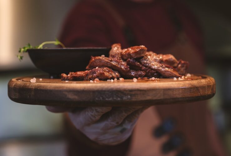 Perfectly shredded healthy crockpot pulled pork served on a rustic wooden platter with fresh herbs and colorful vegetables