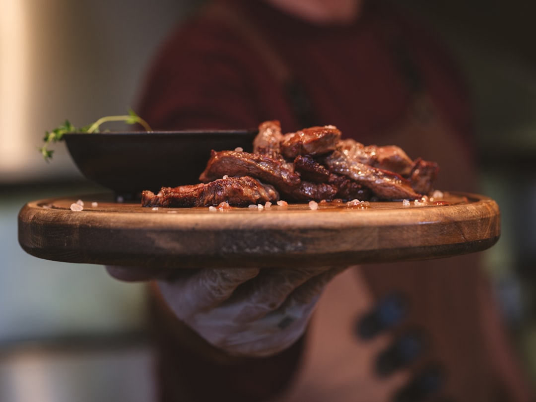 Perfectly shredded healthy crockpot pulled pork served on a rustic wooden platter with fresh herbs and colorful vegetables