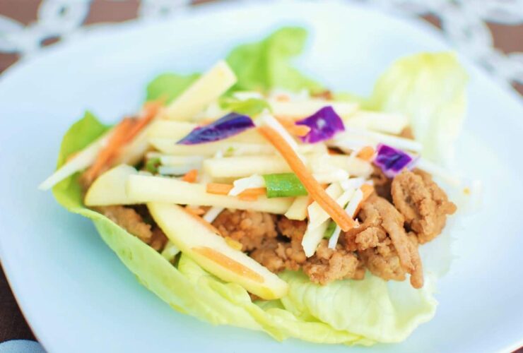Hoisin turkey lettuce wraps arranged on white platter with garnishes
