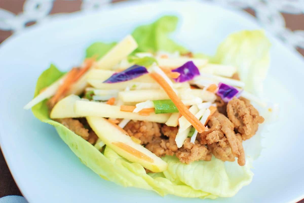 Hoisin turkey lettuce wraps arranged on white platter with garnishes