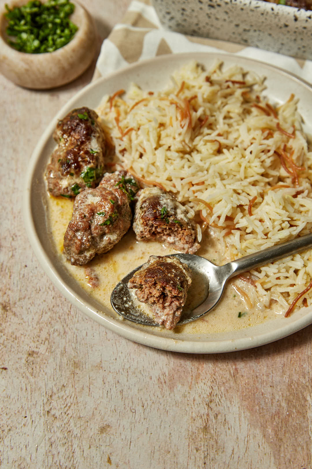 Lebanese Kafta Kebabs: Healthy Grilled Perfection with Aromatic Spices 28 Close-up of sliced kafta kebab showing the herb-flecked interior, served on a bed of fluffy rice with a dollop of tahini sauce