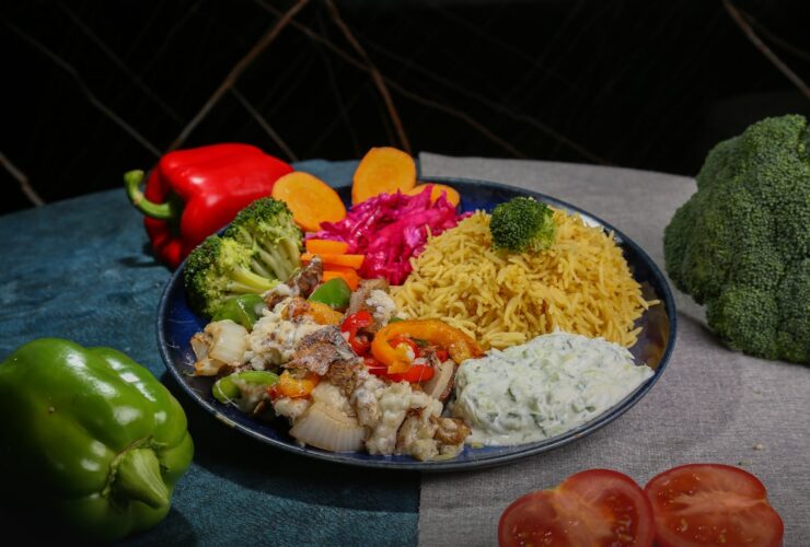 Mediterranean chicken bowl with golden herb-crusted chicken, colorful vegetables, quinoa and tzatziki beautifully arranged in a white ceramic bowl