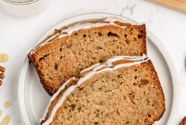 Perfect Zucchini Bread Recipe - Moist, Sweet & Easy to Make 27 golden brown zucchini bread loaf sliced on wooden cutting board with butter and honey