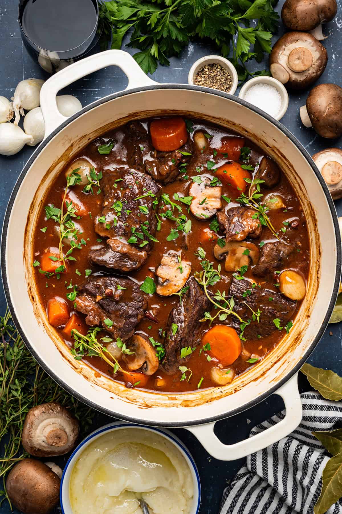 Elegant beef bourguignon in a rustic ceramic bowl with tender beef chunks, pearl onions, and mushrooms in rich wine sauce, garnished with fresh thyme