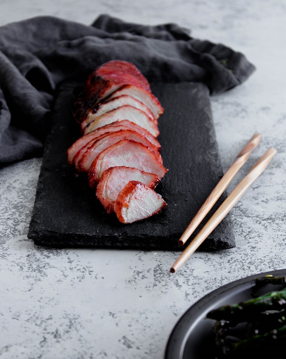 Close-up shot of sliced char siu pork showing the caramelized edges and juicy interior, served over steamed rice