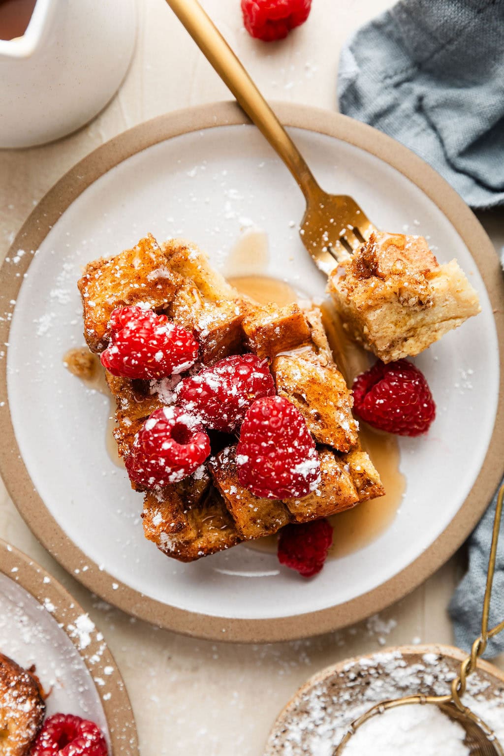 French Toast Casserole - Make-Ahead Breakfast with Clean Ingredients & Nutritional Benefits 26 Golden French toast casserole in white baking dish with fresh berries and powdered sugar dusting, styled on rustic wooden table with morning sunlight