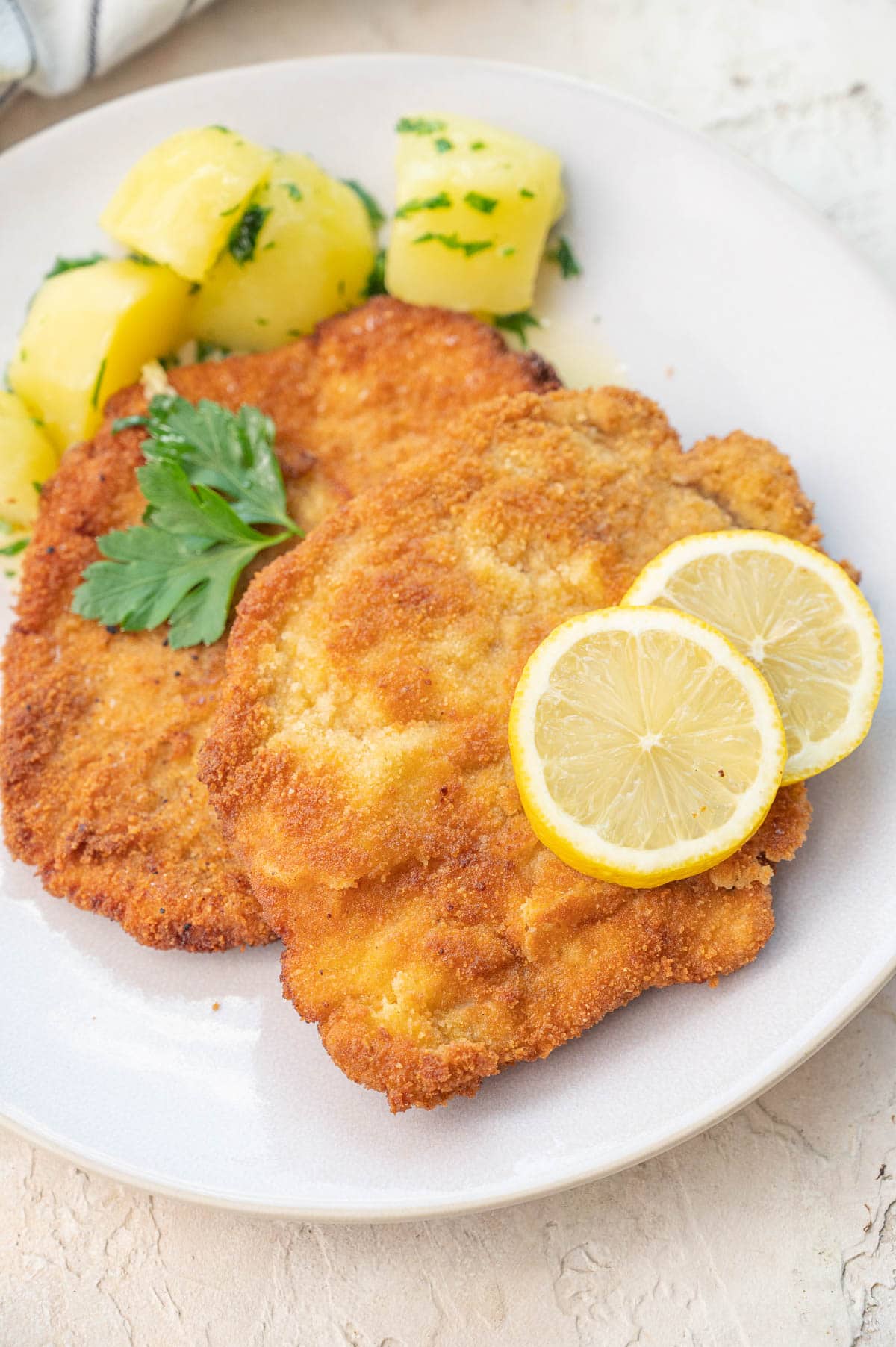 German Schnitzel Recipe - Classic European Comfort Food with Nutritional Benefits 28 Close-up shot of sliced German schnitzel showing the golden crispy coating and tender, juicy interior with a squeeze of fresh lemon