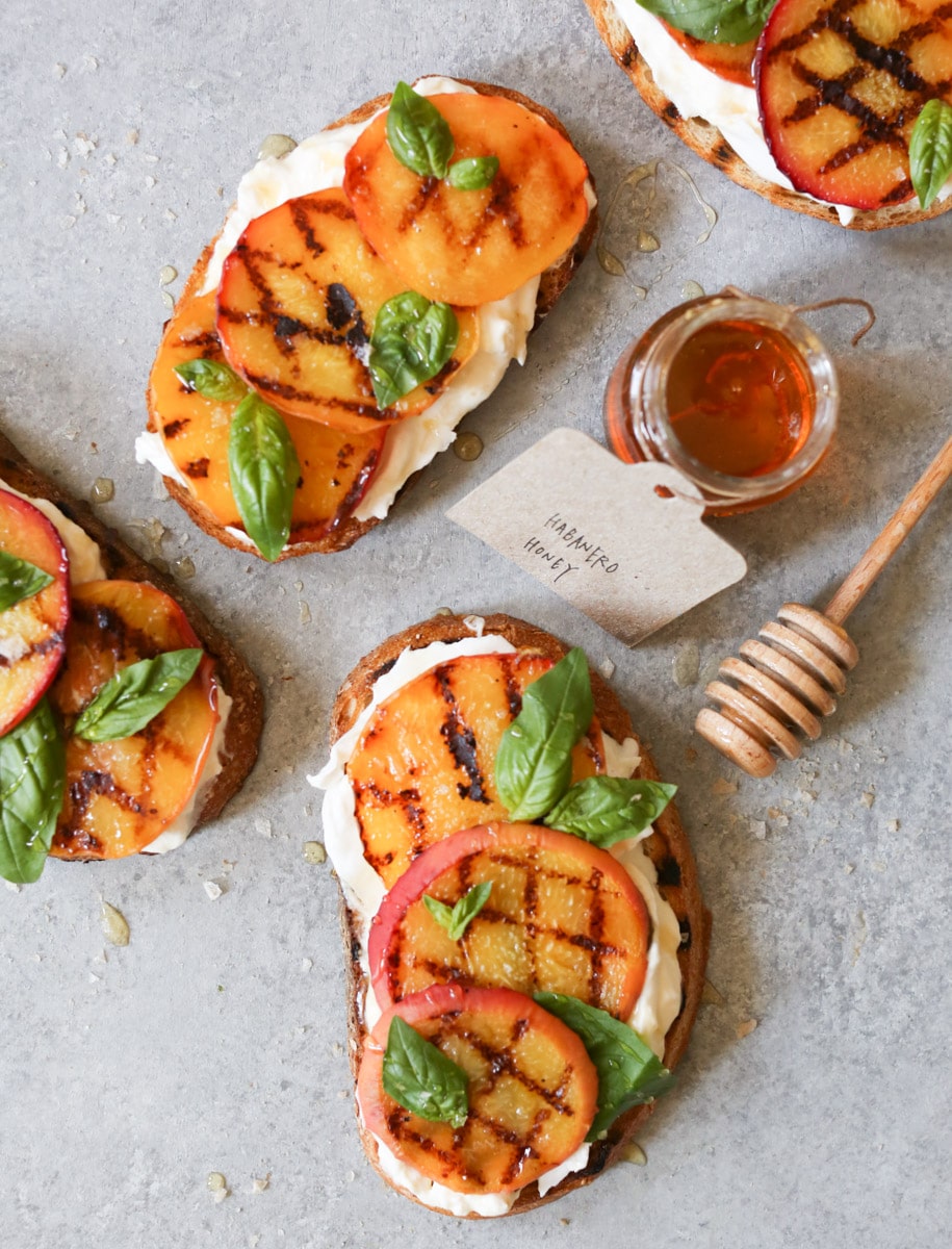 Grilled Peach Burrata Breakfast Toast - Healthy Italian-Inspired Morning Recipe 26 Grilled peach and burrata toast on whole grain bread beautifully plated on rustic wooden board with fresh basil garnish and drizzle of honey