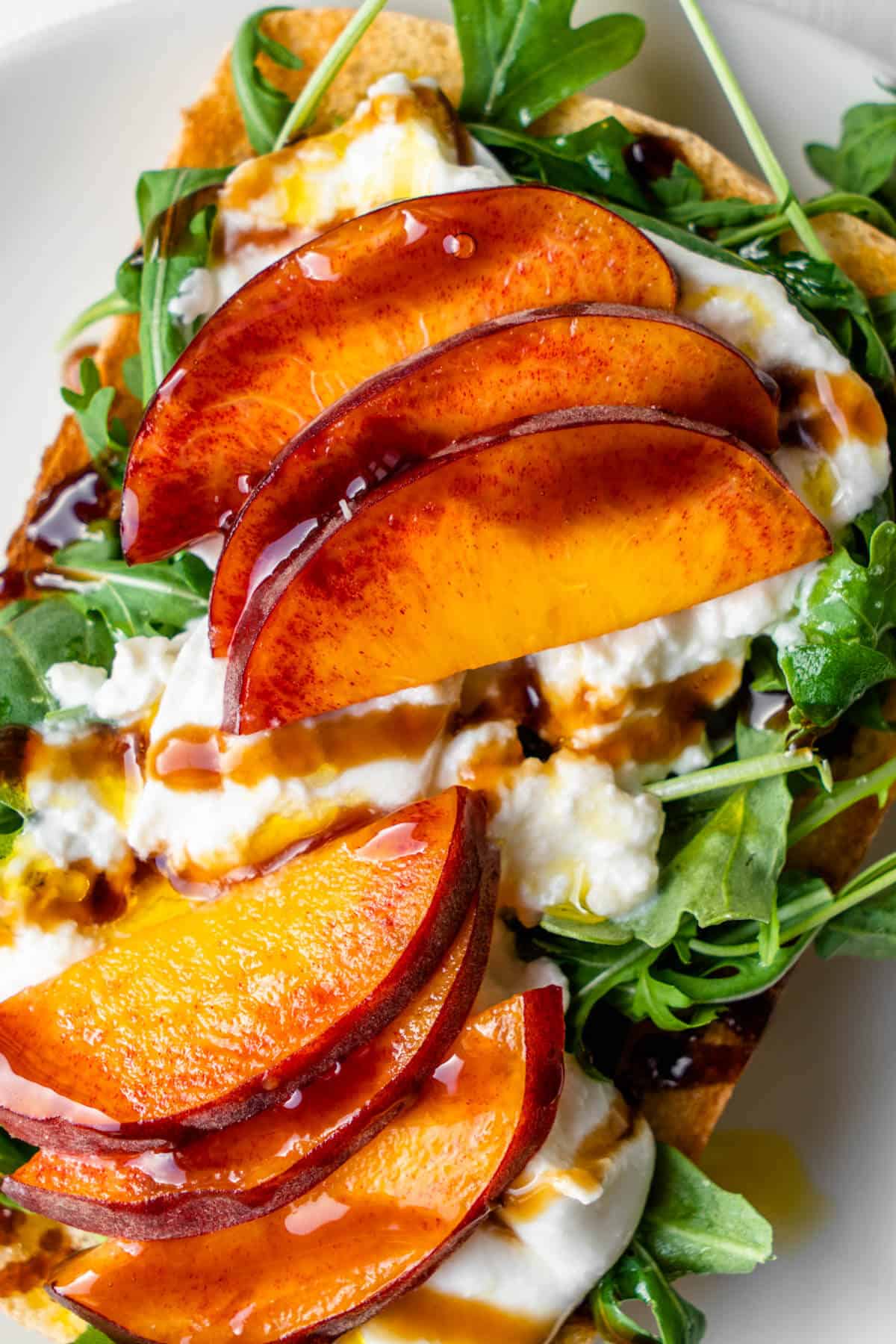 Grilled Peach Burrata Breakfast Toast - Healthy Italian-Inspired Morning Recipe 28 Close-up shot of grilled peach and burrata toast showing the creamy cheese texture and caramelized peach details with fresh basil leaves
