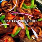 Crispy golden Haitian griot pork pieces garnished with fresh herbs on a white platter with lime wedges