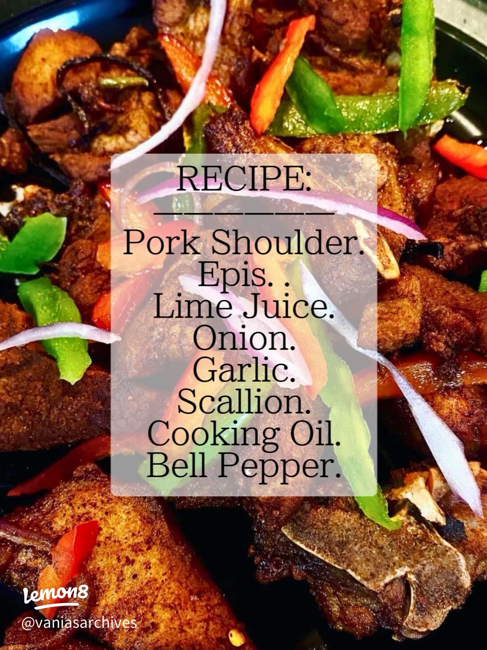 Crispy golden Haitian griot pork pieces garnished with fresh herbs on a white platter with lime wedges