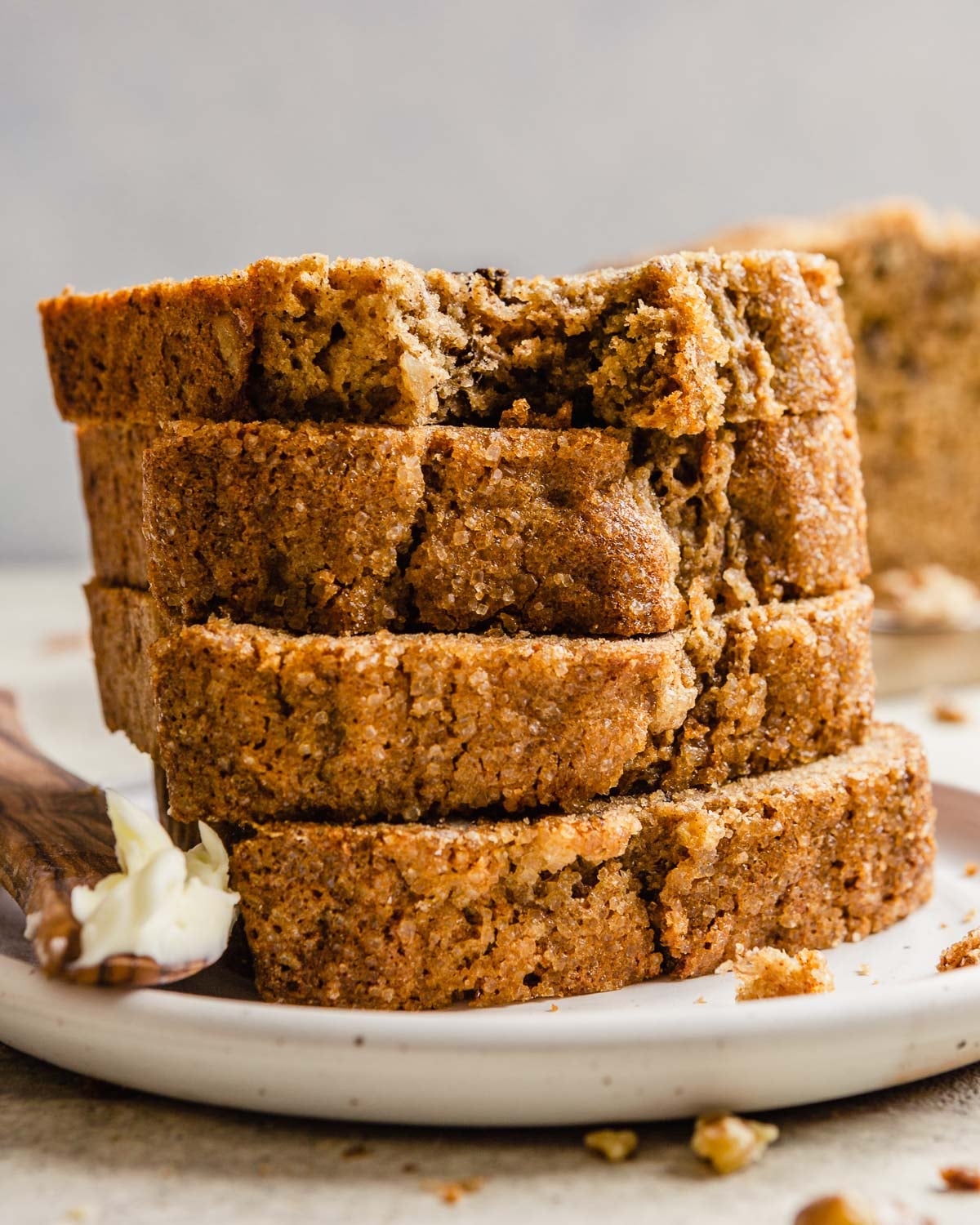 Overripe bananas, whole wheat flour, Greek yogurt, and other ingredients arranged on a marble countertop with measuring cups