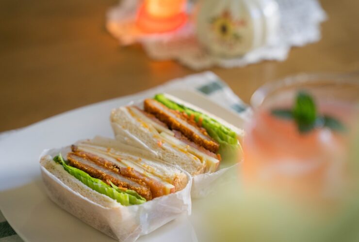 Beautiful banh mi sandwich cut in half showing colorful layers of pickled vegetables, fresh herbs, protein and Vietnamese mayo on crusty French bread