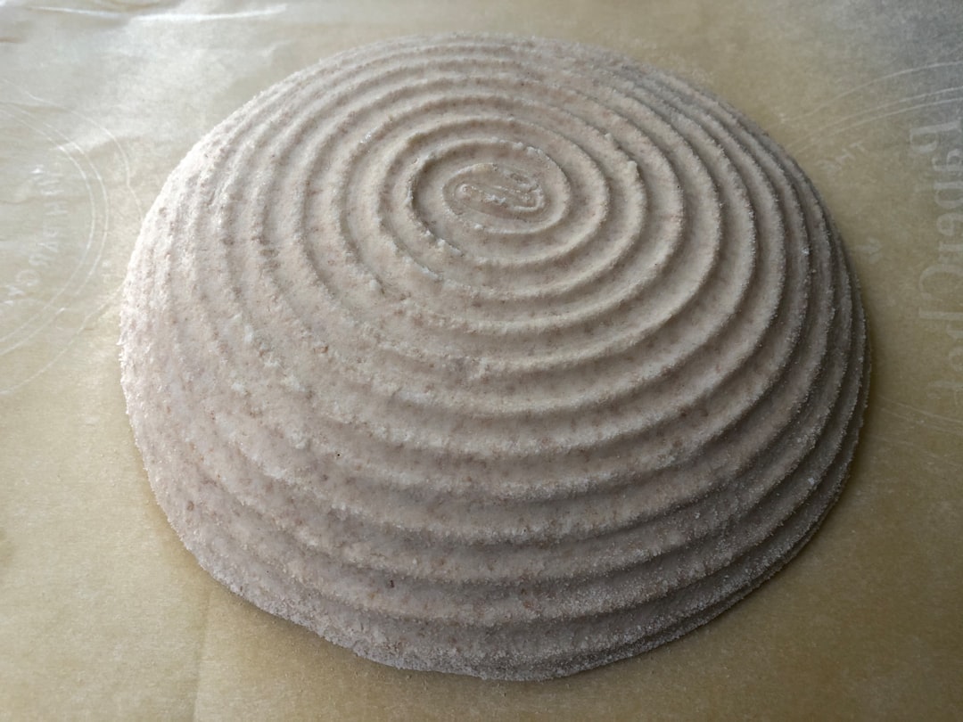 Hands rolling cinnamon roll dough with filling visible, showing the spiral technique and even distribution of cinnamon mixture