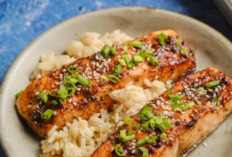Beautifully plated miso glazed salmon with caramelized golden edges, garnished with sesame seeds and scallions on a white plate