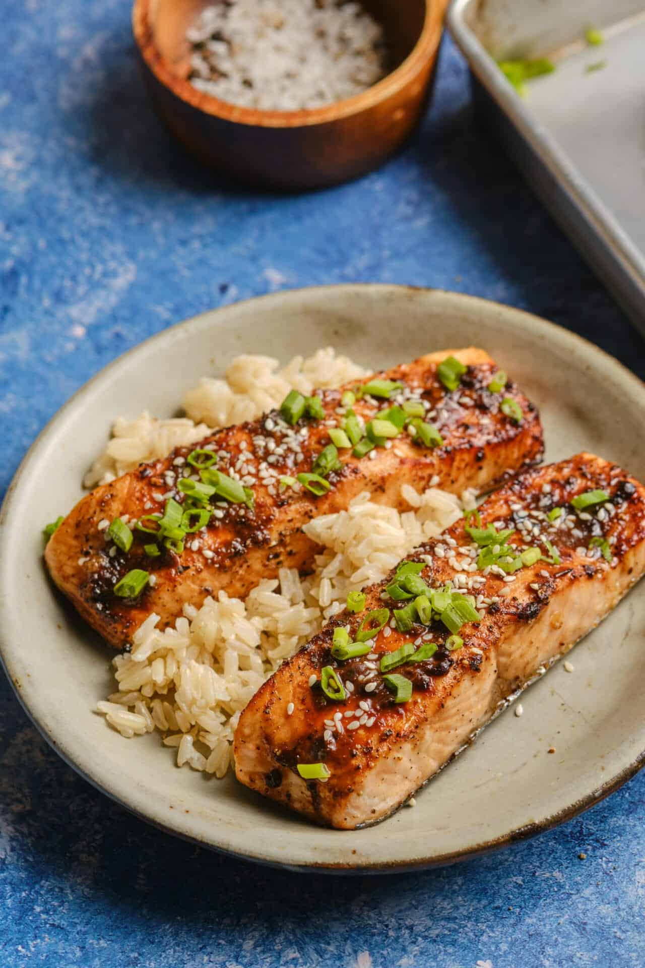 Beautifully plated miso glazed salmon with caramelized golden edges, garnished with sesame seeds and scallions on a white plate