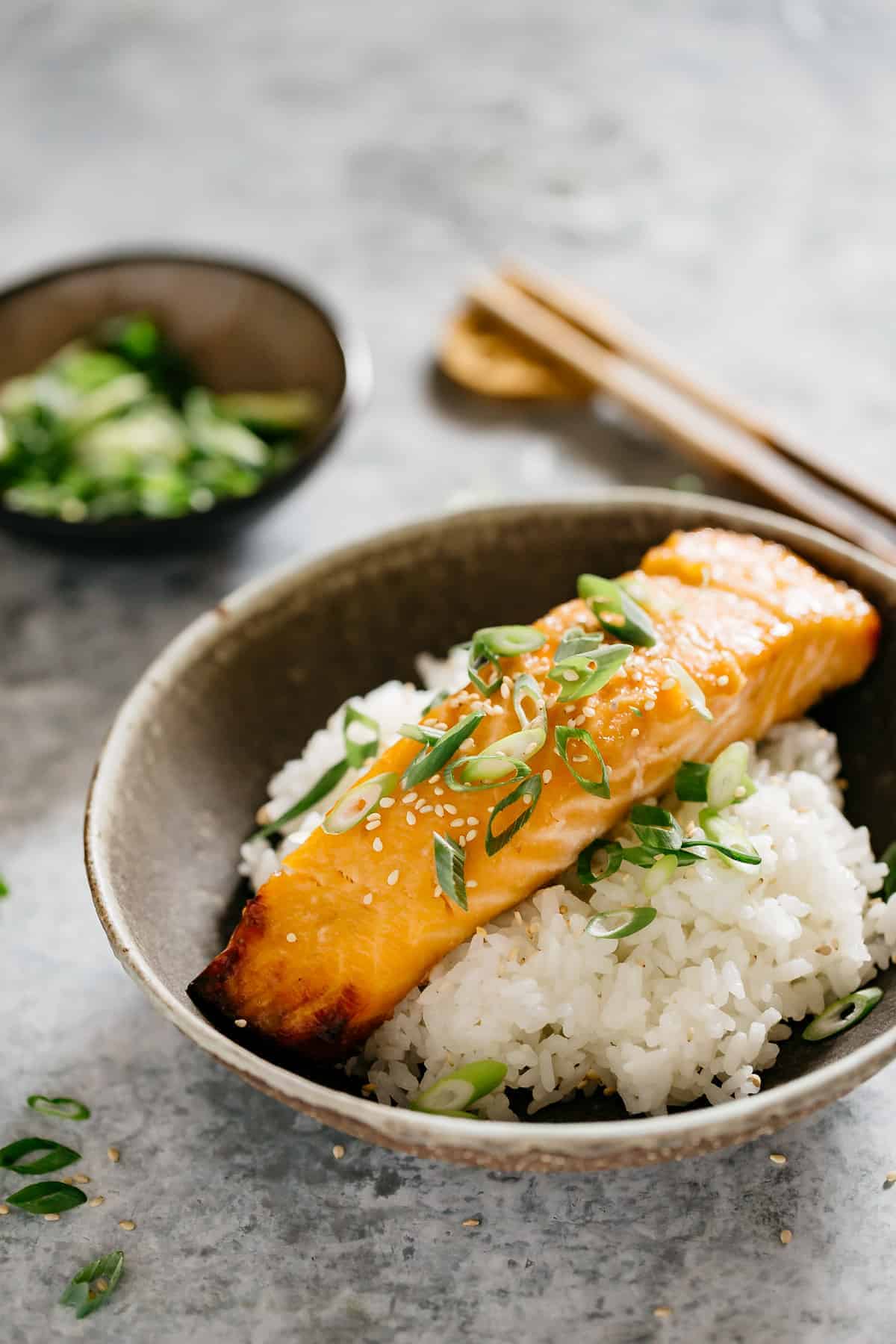 Step-by-step shot showing salmon fillets being brushed with golden miso glaze, with small bowls of ingredients nearby
