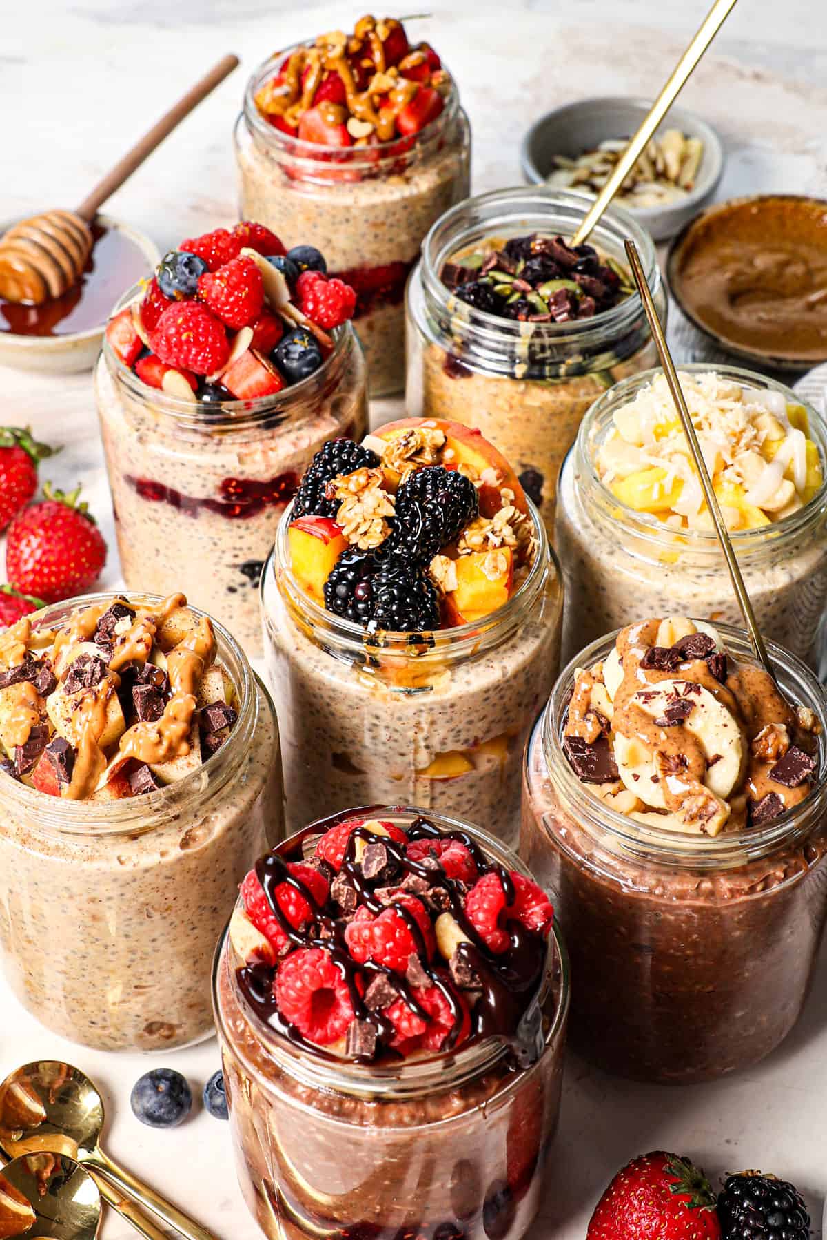 Overnight Oats Summer Berry Recipe — The Ultimate No-Cook Breakfast Jar 28 Close-up macro shot of a single mason jar of overnight oats topped with a crown of fresh blueberries, halved strawberries, and raspberries, with a drizzle of honey catching the light and a sprig of fresh mint tucked into the side