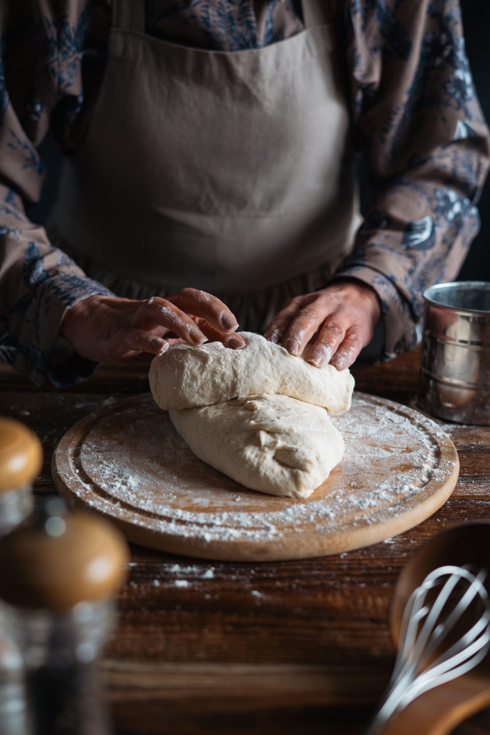 Hands kneading sourdough dough on floured surface showing proper texture and gluten development