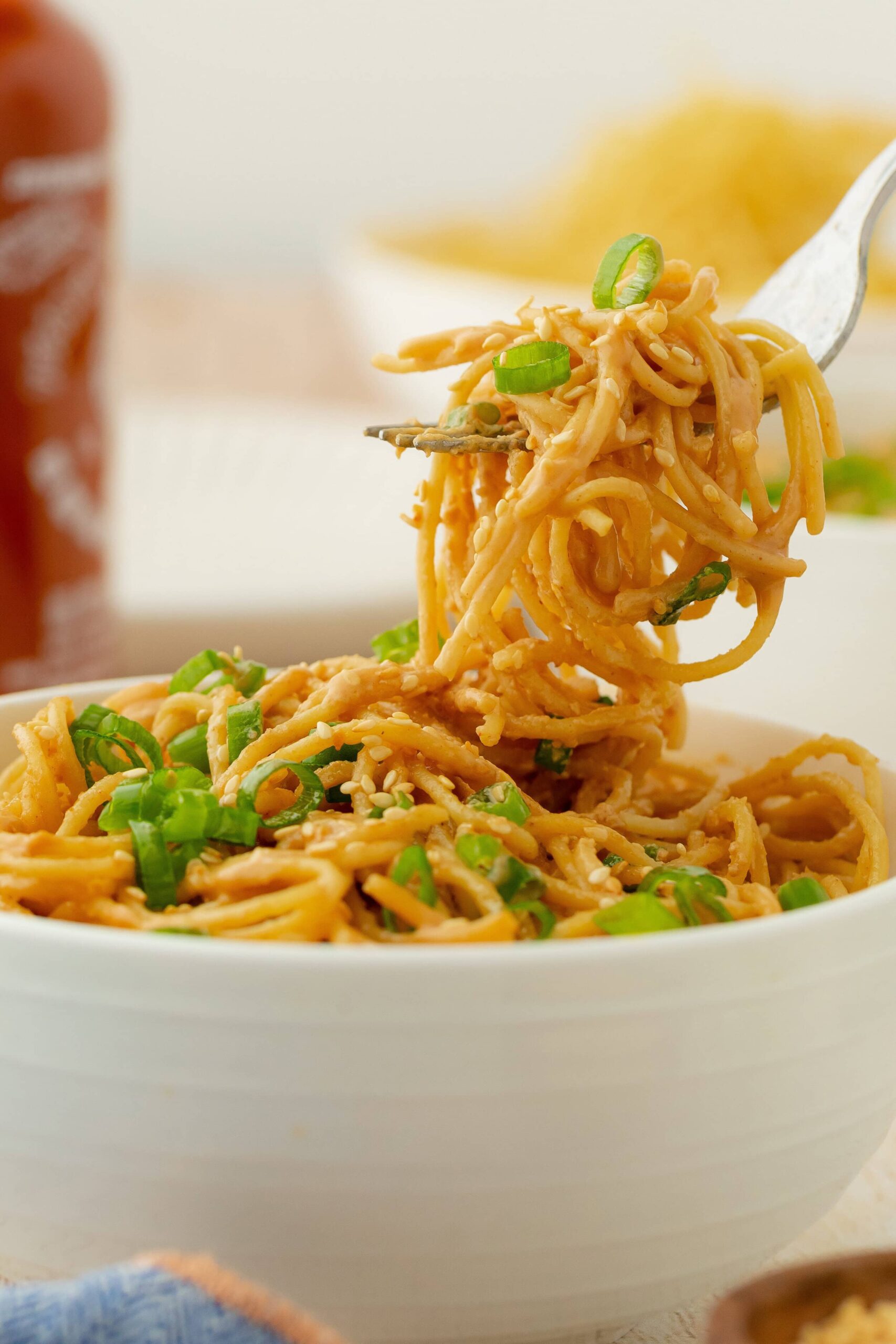 Cold Sesame Noodles — No-Cook Spicy Peanut Noodles Ready in 15 Minutes 28 Close-up of cold sesame noodles twirled on a fork with visible sesame seeds, chopped scallions, julienned cucumber, and a glossy peanut sesame sauce coating every strand