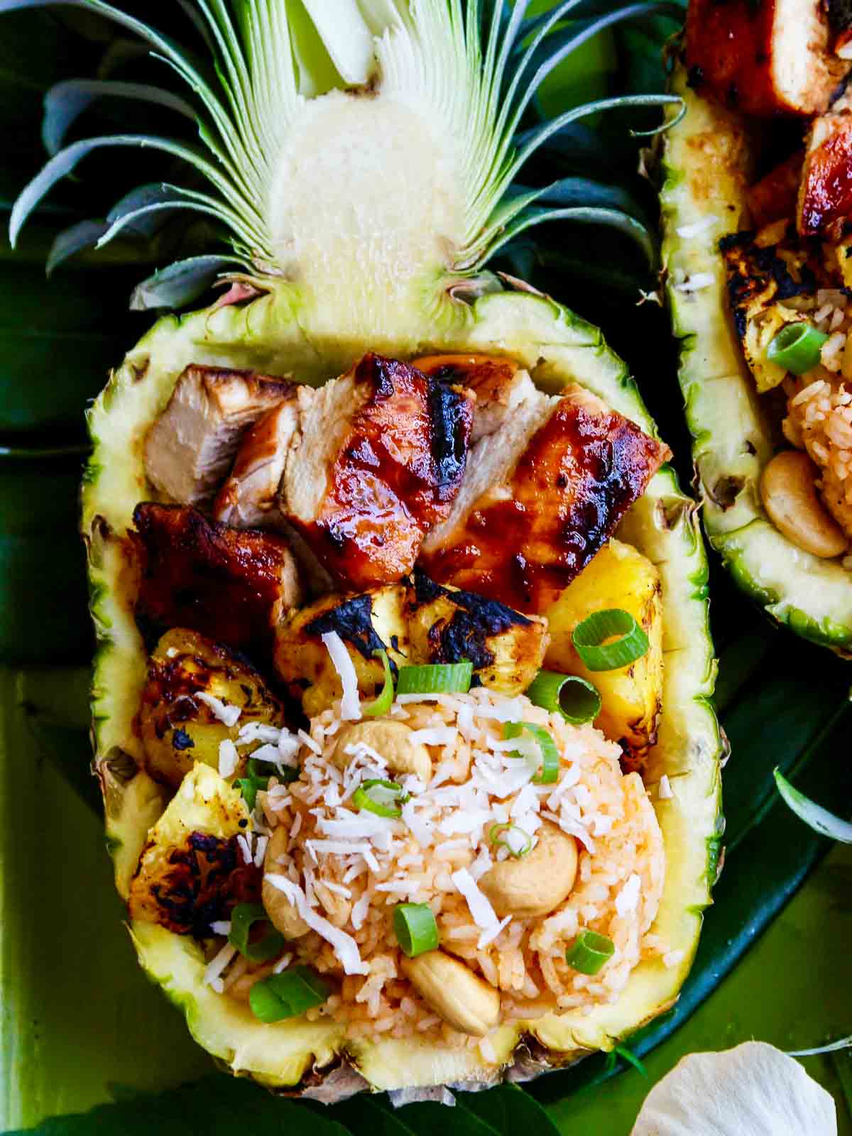 Huli Huli Chicken — Hawaiian Sweet Pineapple BBQ Glaze Recipe 26 Huli Huli Chicken glazed with pineapple BBQ sauce plated on a wooden board with grilled pineapple slices and fresh herbs