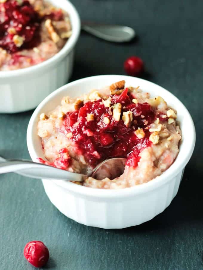 Overnight Camping Oatmeal — The Easy, Nourishing Breakfast You Prep Before You Even Leave Home 28 Close-up overhead shot of a bowl of creamy overnight camping oatmeal topped with golden toasted walnuts, plump dried cranberries, a swirl of honey, and a dusting of cinnamon, photographed in warm morning light with a rustic wooden spoon resting on the side