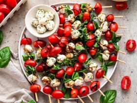 Caprese Skewers — Cherry Tomato Mozzarella Basil Bites Everyone Loves 34 Caprese skewers beautifully plated on a white marble board with cherry tomatoes, fresh mozzarella, and basil leaves drizzled with balsamic glaze and olive oil
