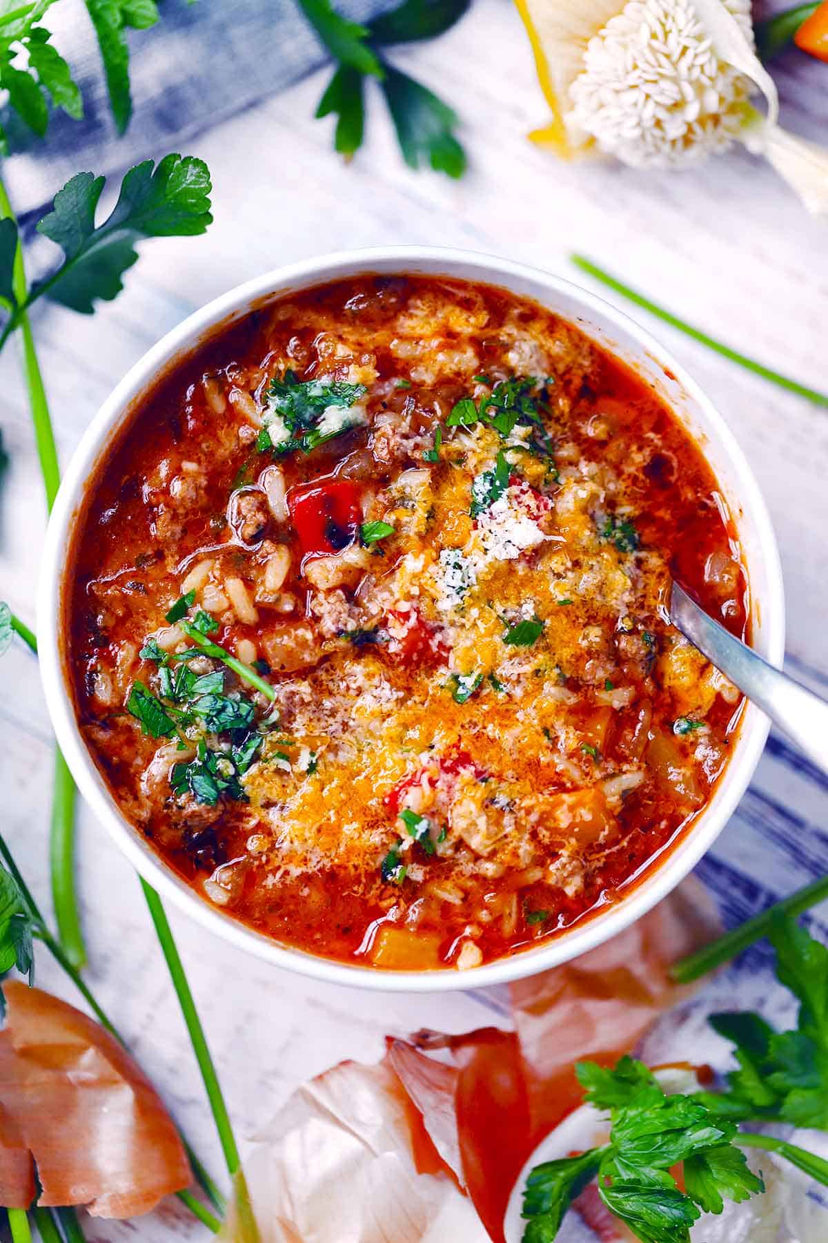 Crockpot Stuffed Pepper Soup — All the Comfort of Stuffed Peppers in One Easy Bowl 27 Overhead flat-lay of all Crockpot Stuffed Pepper Soup ingredients laid out on a white marble surface including ground beef, diced bell peppers, crushed tomatoes, rice, broth, and seasonings