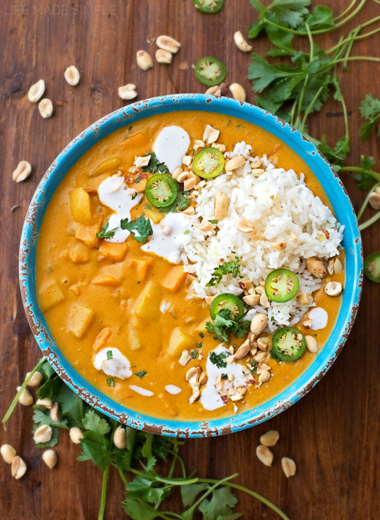 Faux-Massaman Vegetable Curry — Rich, Warming & Deeply Satisfying 27 Overhead flat-lay of faux-massaman vegetable curry ingredients including coconut milk can, yellow curry paste, peanut butter, sweet potato, carrots, and whole spices on a wooden surface