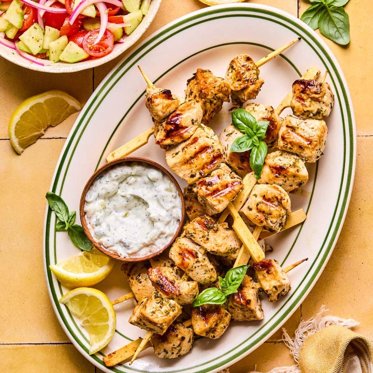 Grilled Chicken Skewers with Tzatziki — Greek-Inspired Camp Grill Recipe 27 Overhead flat lay of grilled chicken skewer ingredients — marinated chicken pieces, lemon, garlic, fresh herbs, and a jar of tzatziki on a camp table