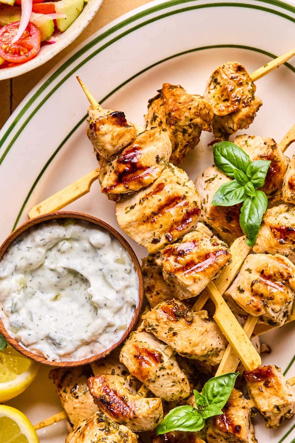 Grilled Chicken Skewers with Tzatziki — Greek-Inspired Camp Grill Recipe 28 Close-up of grilled chicken skewers resting on a wooden board with a side bowl of creamy tzatziki, fresh dill garnish, and lemon wedges