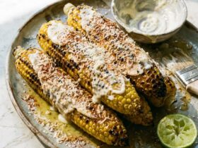 Grilled Corn on the Cob — Charred Butter Parmesan Elote Style 37 Grilled corn on the cob with charred kernels, butter, Parmesan, chili powder, and fresh lime wedges on a rustic wooden board