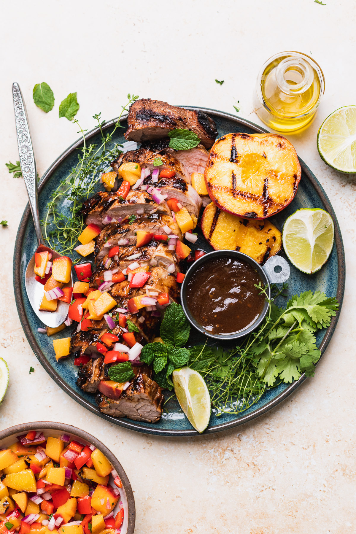 Beautifully plated grilled pork tenderloin sliced on a wooden cutting board with fresh herb garnish, charred grill marks visible, served alongside roasted vegetables