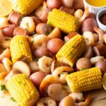 Low Country Shrimp Boil served on a newspaper-lined table with shrimp, corn, sausage, and red potatoes, garnished with lemon wedges and fresh parsley