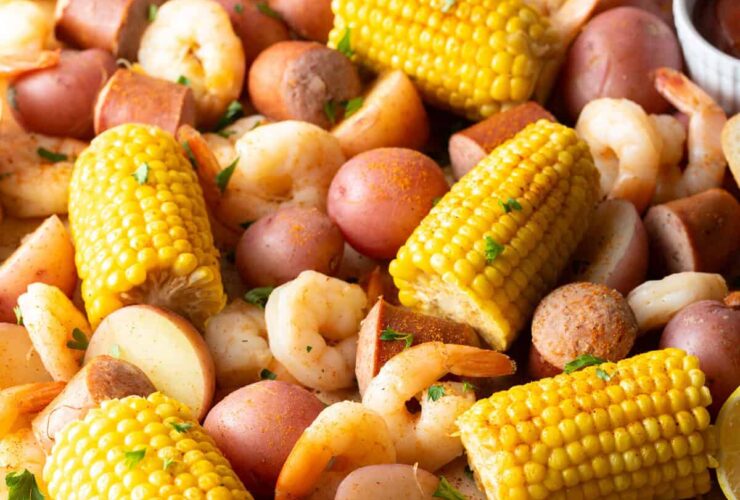 Low Country Shrimp Boil served on a newspaper-lined table with shrimp, corn, sausage, and red potatoes, garnished with lemon wedges and fresh parsley