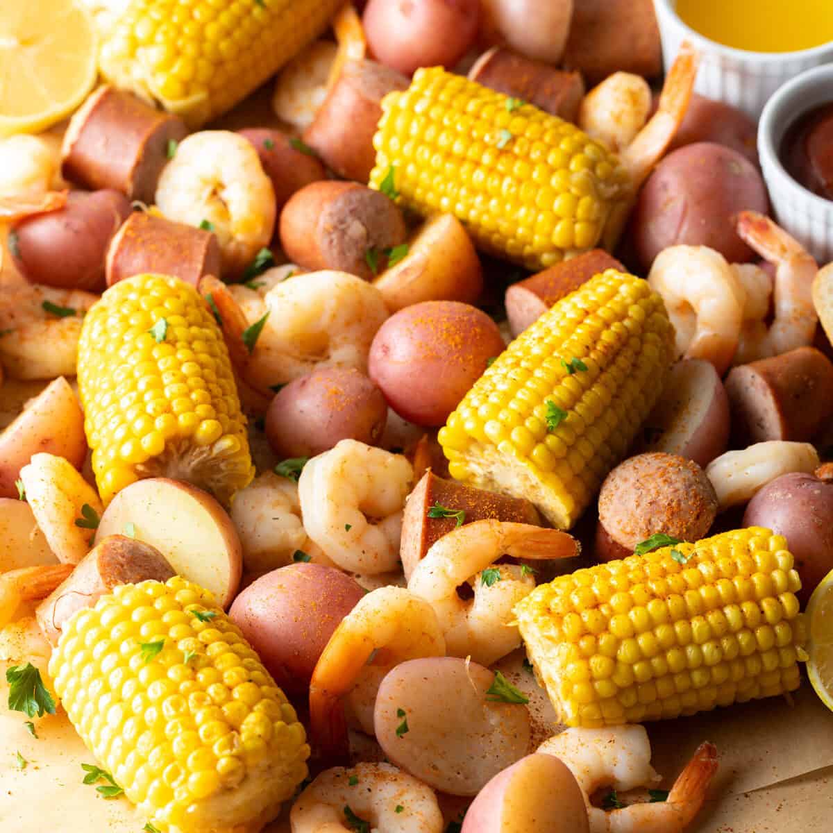 Low Country Shrimp Boil served on a newspaper-lined table with shrimp, corn, sausage, and red potatoes, garnished with lemon wedges and fresh parsley