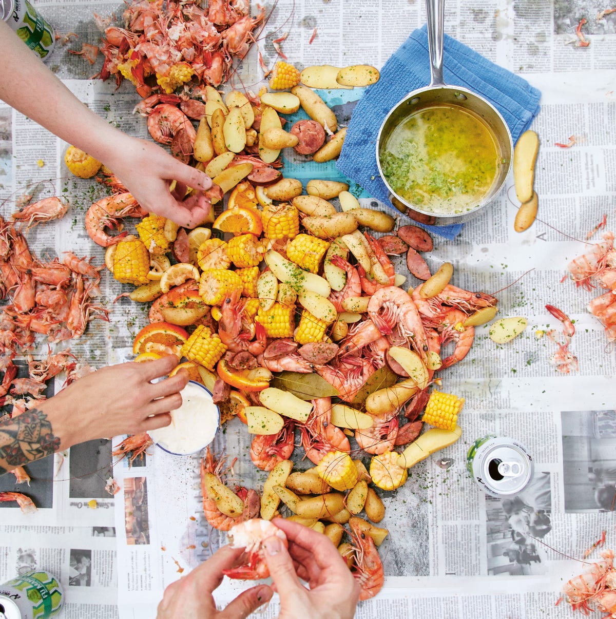 Close-up of Low Country Shrimp Boil in a bowl with melted butter drizzle, lemon wedge, and fresh parsley, rustic wooden table background