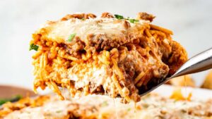 Million Dollar Spaghetti baked casserole golden cheesy top fresh from the oven in a white baking dish