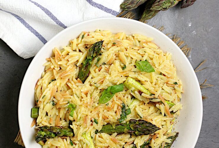 One-Pot Cheesy Orzo with Asparagus — No-Colander Pasta Cooked Entirely in a Single Pot 27 One-pot cheesy orzo with asparagus served in a wide shallow bowl, topped with freshly grated parmesan and cracked black pepper, soft natural light overhead