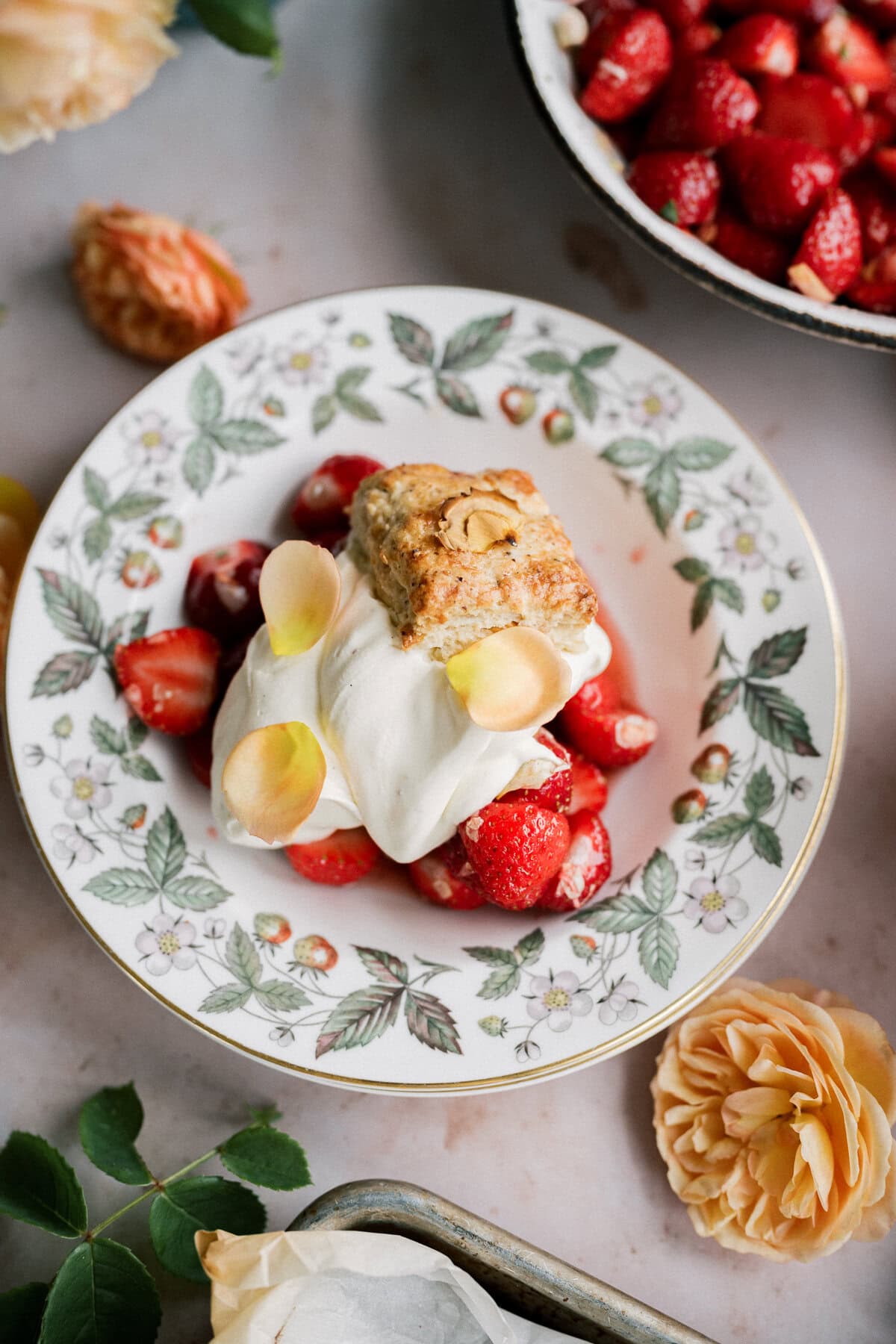 Strawberry Shortcake — The Classic Whipped Cream & Biscuit Dessert Worth Every Bite 26 Classic strawberry shortcake stacked high with fresh sliced strawberries, fluffy whipped cream, and golden biscuits on a white ceramic plate, photographed in natural light