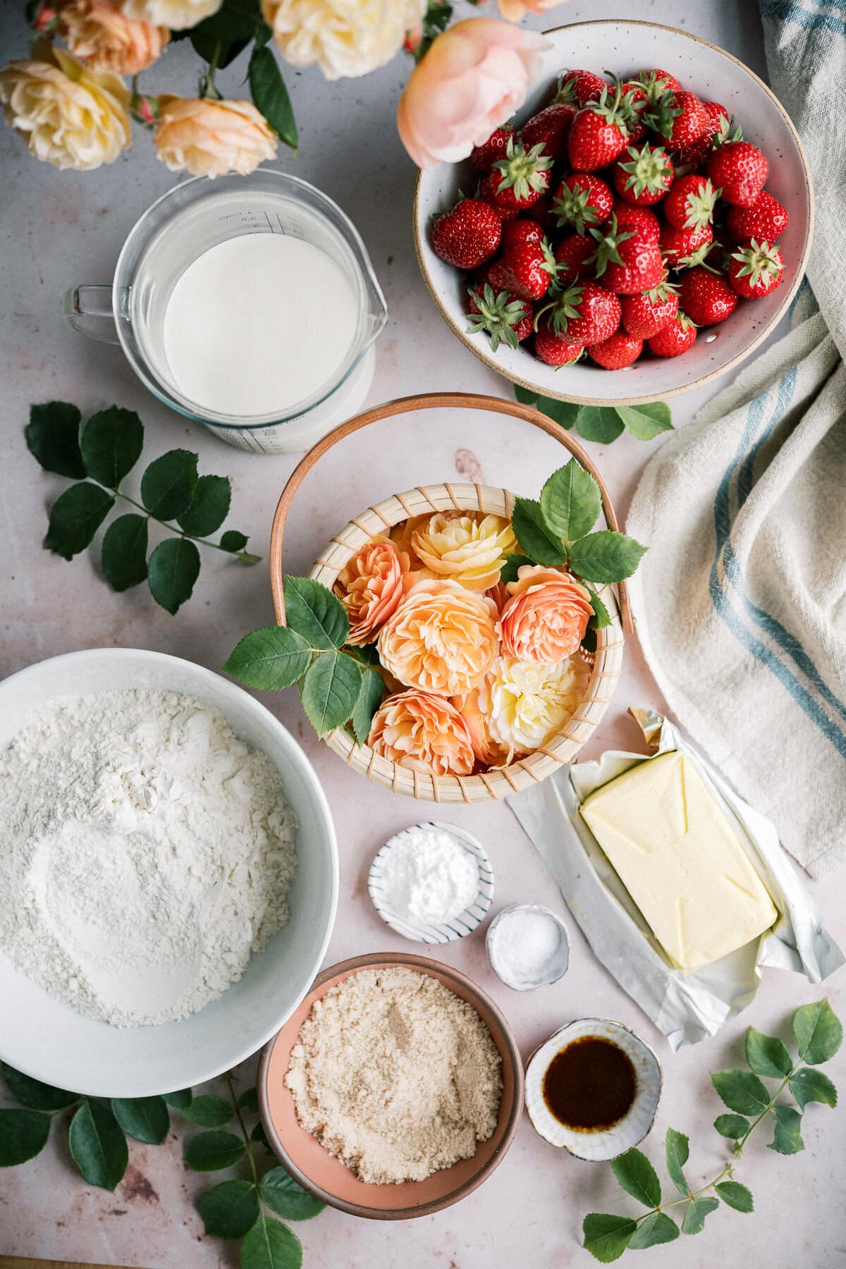 Strawberry Shortcake — The Classic Whipped Cream & Biscuit Dessert Worth Every Bite 27 Overhead flat lay of strawberry shortcake ingredients including fresh strawberries, cold butter cubes, flour, cream, vanilla, and sugar on a white marble surface